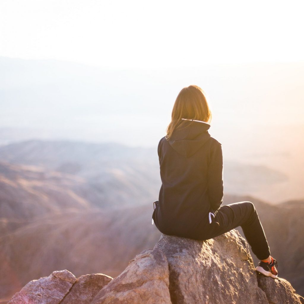 A girl sit on a top of hill and enjoy view of sunlight whatsapp dp image